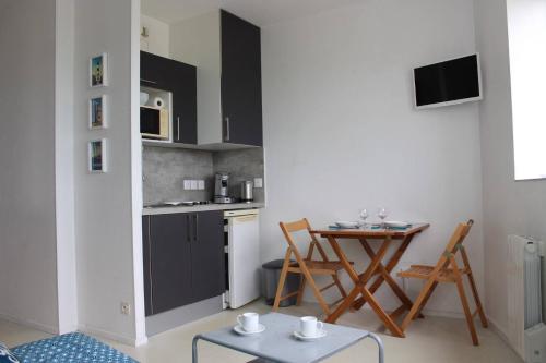 - une cuisine avec une petite table et un comptoir dans l'établissement Appt Studio LA ROCHELLE - LR110-F34, à La Rochelle