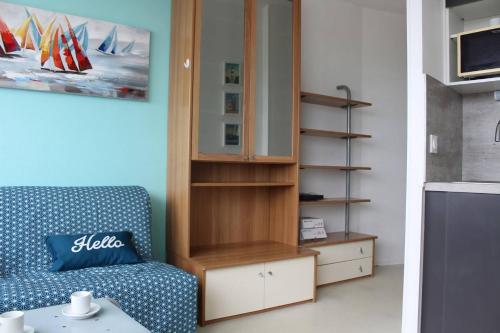 un salon avec un canapé bleu et une armoire dans l'établissement Appt Studio LA ROCHELLE - LR110-F34, à La Rochelle