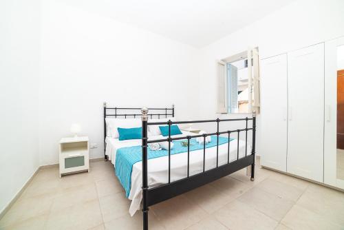 a bedroom with a bed with blue pillows at Casa degli Oleandri in Ostuni