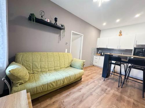 a living room with a green couch and a kitchen at Cozy Apartments in Central Location with Free Parking on Availability in Vienna