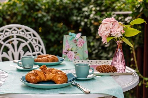 a table with plates of croissants and cups of coffee at Pension Landhaus- Frühstückspension im Brombachtal in Brombachtal