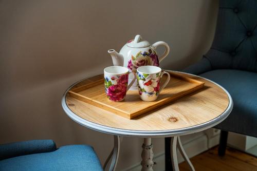 a tea pot and two cups on a tray on a table at Pension Landhaus- Frühstückspension im Brombachtal in Brombachtal