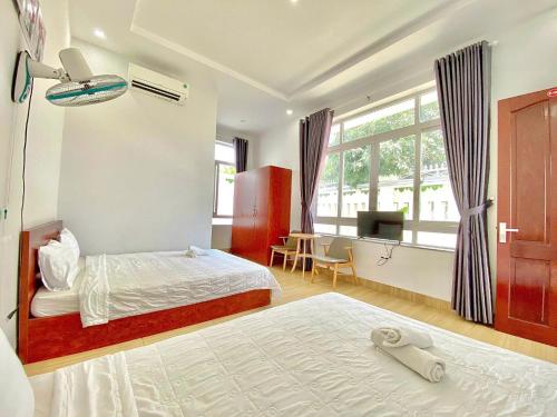 a bedroom with a bed and a desk and a television at Serina Villa Pool Beach in Vung Tau