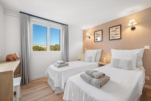 deux lits dans une chambre avec une fenêtre dans l'établissement Le Duplex de la Mer, vue magnifique, accès plage, à Fréjus