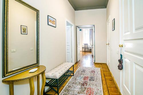 a hallway with a mirror and a chair and a table at White Lilies Spacious 2-Bedroom Sea View in Baku