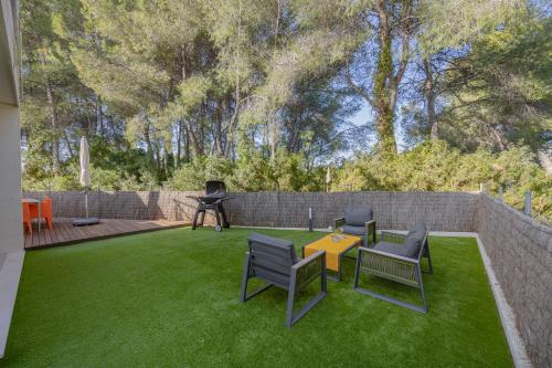 a backyard with a lawn with chairs and a table at Villa PAM, ALYA Beach House with pool and Hot Tub in Alcudia