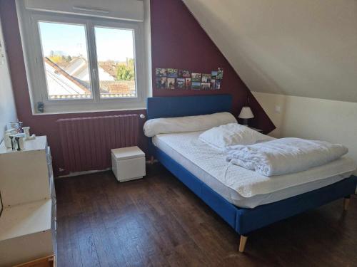 - une petite chambre avec un lit bleu et une fenêtre dans l'établissement L'instant présent - Chambre Alyzée, à Salbris