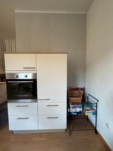 a white cabinet in a kitchen with a oven at Ferienhaus Löwenherz in Pommern