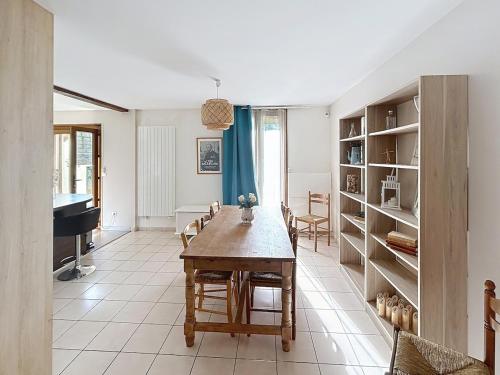 un salon avec une table et un piano dans l'établissement Maison Auriane 3 minutes de la gare, à Margny-lès-Compiègne