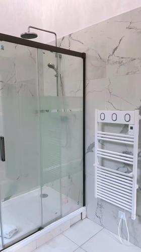 une douche avec une porte vitrée dans une salle de bain dans l'établissement 2P dans luxueuse villa, à Nice