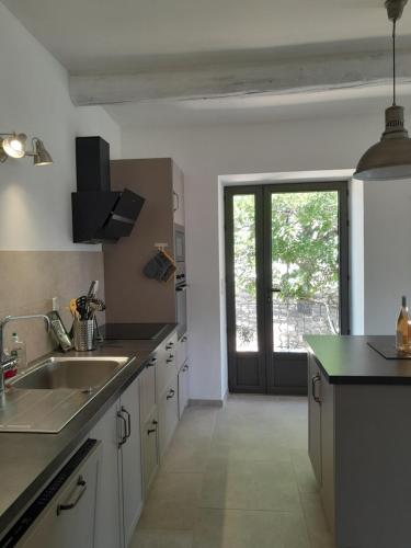 une cuisine avec un évier et une grande fenêtre dans l'établissement LA GALINE, à Ménerbes