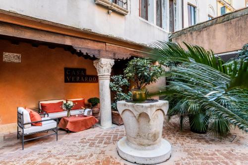 a patio with chairs and a large urn with plants at Hotel Casa Verardo Residenza d'Epoca in Venice
