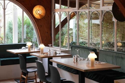 a restaurant with two tables and chairs and windows at Logis Thermal in Saubusse