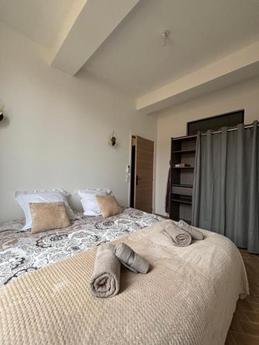 une chambre avec un grand lit avec des serviettes dessus dans l'établissement HomeForville, à Cannes
