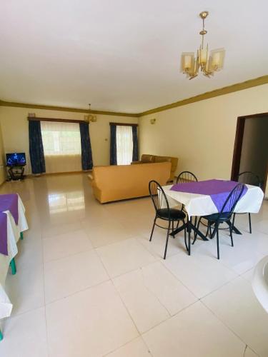 a living room with a table and chairs and a couch at Private Palace in Arua
