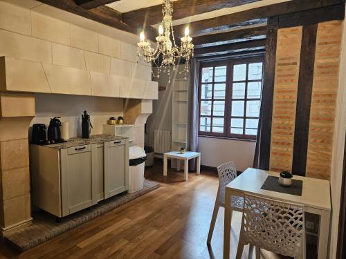 une cuisine avec une table et un lustre dans l'établissement Nid douillet dans vieux-Tours, à Tours