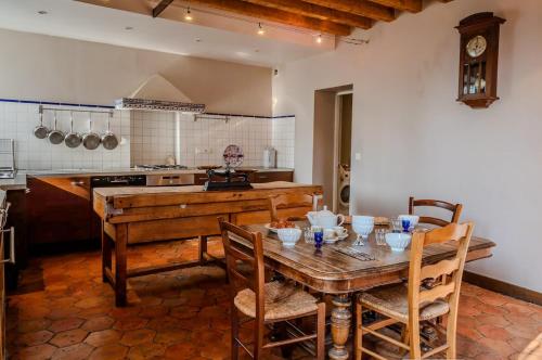 une cuisine avec une table en bois et une table et des chaises dans l'établissement Grande Maison de Charme- 14 pers- 1h Paris, à Gressey