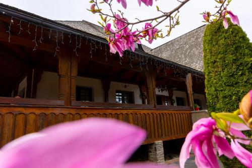 a house with a wooden fence and pink flowers at Casa Elena - Resort & SPA in Voronet