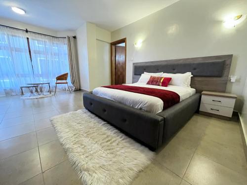 a bedroom with a large bed and a rug at Nakuru CBD Luxury Suites With Heated Pool, GYM, Secure Parking in Nakuru