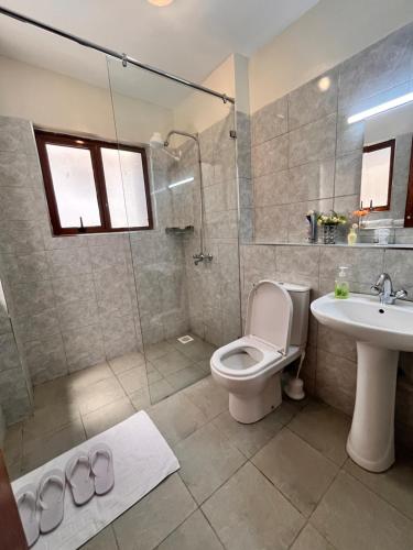 a bathroom with a toilet and a sink and a shower at Nakuru CBD Luxury Suites With Heated Pool, GYM, Secure Parking in Nakuru