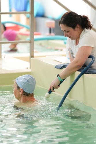 a woman playing with a man in the water at Logis Thermal in Saubusse