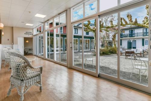 a hallway with large windows and a bench at Logis Thermal in Saubusse