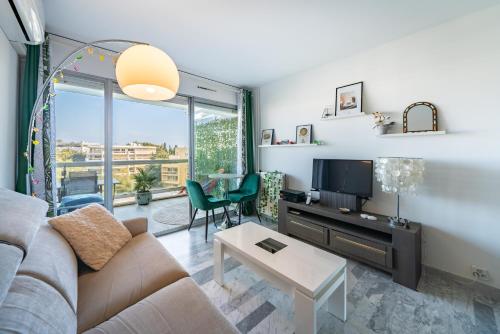 un salon avec un canapé et une télévision dans l'établissement Studio vue mer et montagnes, avec piscine, à Antibes