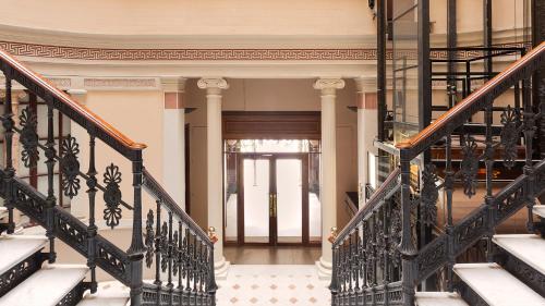 an ornate staircase in a home with wrought iron railings at Hostal Oliva in Barcelona