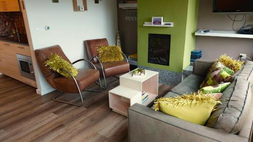a living room with a couch and two chairs at Vakantiehuis Jade in Bruinisse
