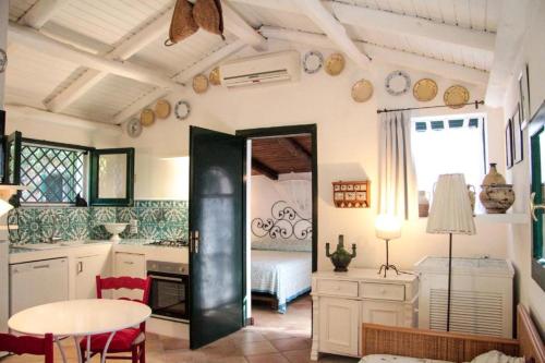 a kitchen with a table and a dining room at Le Case Rosa vicino Tropea in Santa Domenica
