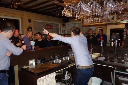 a man standing at a bar with his arm out at Elckerlyck Inn Hotel in Rollegem