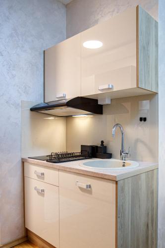 a kitchen with white cabinets and a sink at JEZERSKA RESIDENCE Palić in Palić