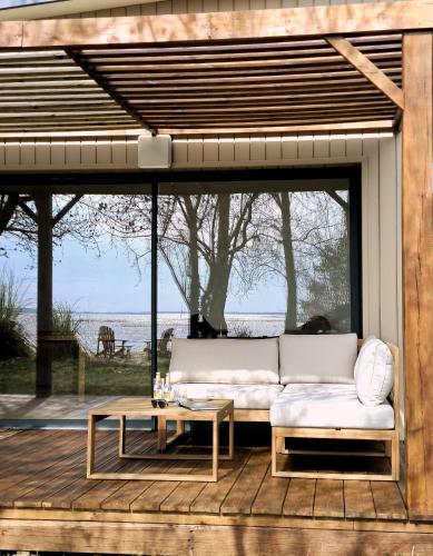 a white couch on a deck with a table at Hôtel Latécoère in Biscarrosse