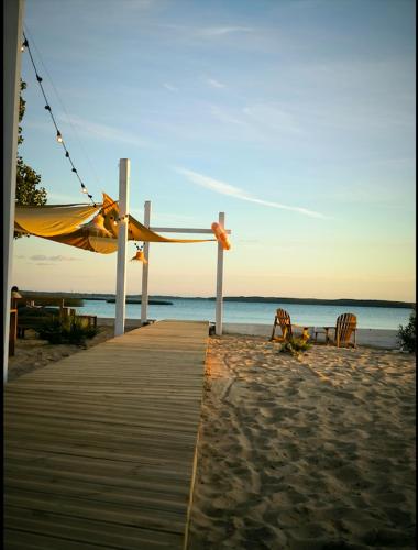 a wooden boardwalk on the beach with chairs at Hôtel Latécoère in Biscarrosse