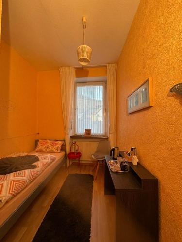 a bedroom with orange walls and a bed and a window at Ferienhaus Löwenherz in Pommern