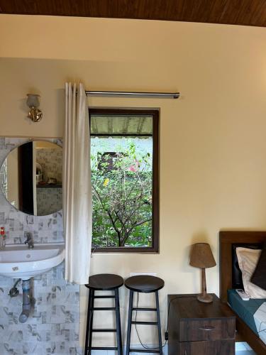 a bedroom with a sink and two stools in front of a window at Cute Studio at Portuguese Villa by Goaround Homes in Anjuna