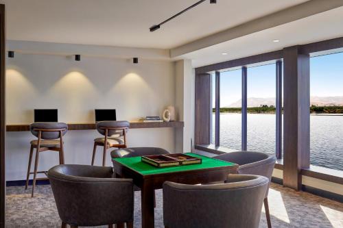 a room with a table and chairs and a view of the water at Mövenpick Royal Lily Nile Cruise, Every Monday Four Nights From Luxor, Every Friday Three Nights From Aswan - Including Excursions & Sightseeing in Luxor