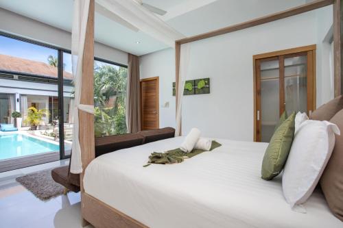 a bedroom with a large bed and a swimming pool at Luxury 4BR Villa Virginie, Salt Pool, Rawai in Rawai Beach