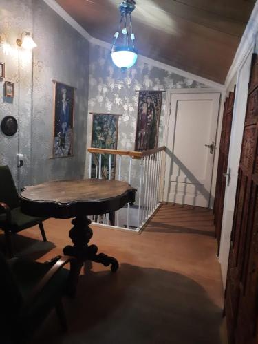 a room with a table and a hallway with a staircase at Tina's Homestay in Tbilisi City