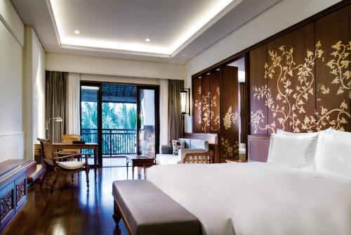 a bedroom with a large bed and a living room at InterContinental Xishuangbanna Resort by IHG in Jinghong