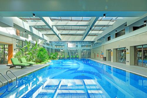 a large swimming pool in a large building at InterContinental Xishuangbanna Resort by IHG in Jinghong