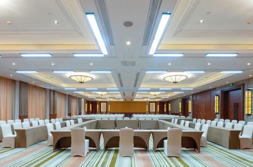 a large room with rows of tables and white chairs at InterContinental Xishuangbanna Resort by IHG in Jinghong