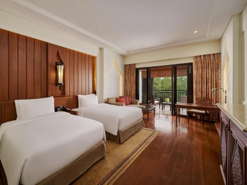 a hotel room with two beds and a piano at InterContinental Xishuangbanna Resort by IHG in Jinghong