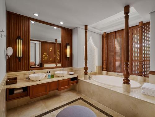 a bathroom with two sinks and a bath tub at InterContinental Xishuangbanna Resort by IHG in Jinghong