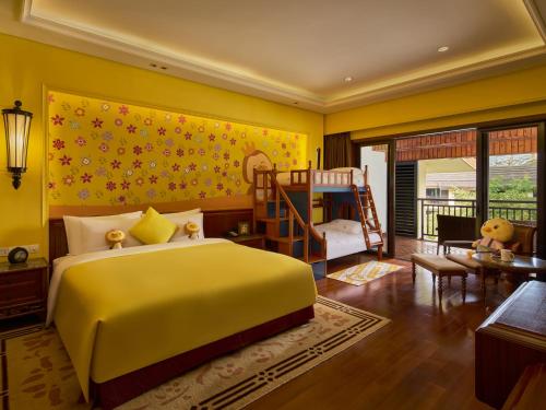 a yellow bedroom with a bed and a bunk room at InterContinental Xishuangbanna Resort by IHG in Jinghong