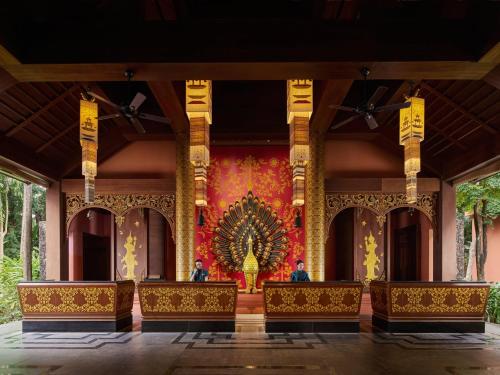 a stage with two people sitting in front of a wall at InterContinental Xishuangbanna Resort by IHG in Jinghong