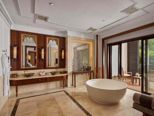 a bathroom with a large tub and two sinks at InterContinental Xishuangbanna Resort by IHG in Jinghong