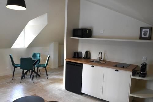 une cuisine avec un évier et une table avec des chaises dans l'établissement Appartement au Domaine 