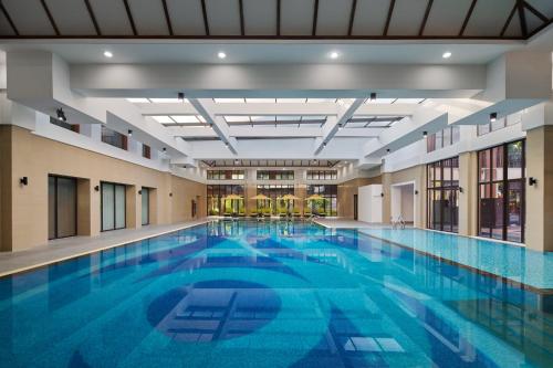a large pool with blue water in a building at InterContinental Xishuangbanna Resort by IHG in Jinghong