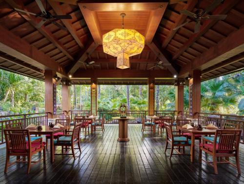 a restaurant with tables and chairs and a chandelier at InterContinental Xishuangbanna Resort by IHG in Jinghong